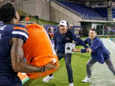 O técnico da UTSA tenta hilariantemente escapar do banho de comemoração e acaba em uma pilha de cães